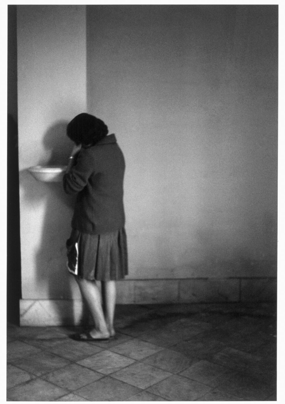 Photographic Social Vision - Una joven en Terrassa reza junto a una pila bautismal. Vallès, 1962.