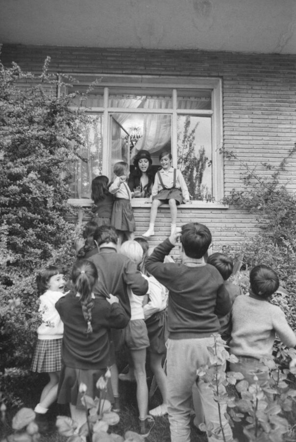 Photographic Social Vision - Massiel saludando a un grupo de niños desde la ventana del atelier de Marbel Jr., mientras asistía a uno de los desfiles del modisto, Madrid, mayo de 1968