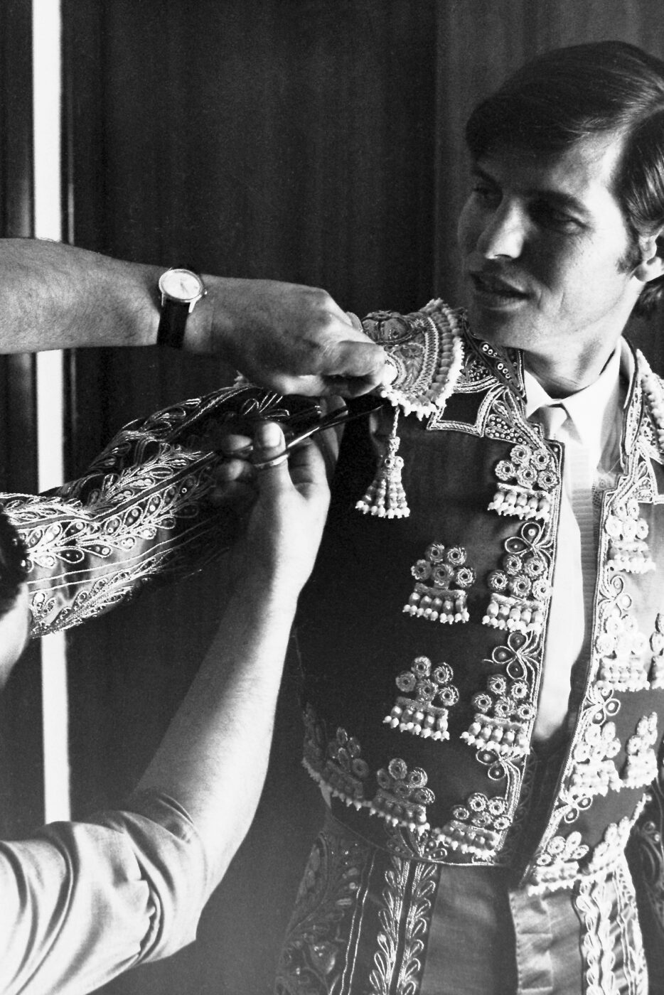 Photographic Social Vision - Manuel Benítez “El Cordobés” mientras le hacen un arreglo a su traje de luces, antes de salir al ruedo. 1965